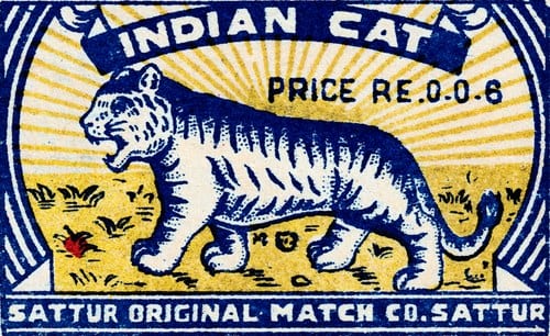 A matchbox label printed in blue and yellow only: a striped tiger walking across a field of sunburst rays, beneath a banner reading INDIAN CAT, with PRICE RE.0.0.6 at the right and SATTUR ORIGINAL MATCH CO. SATTUR along the bottom.
