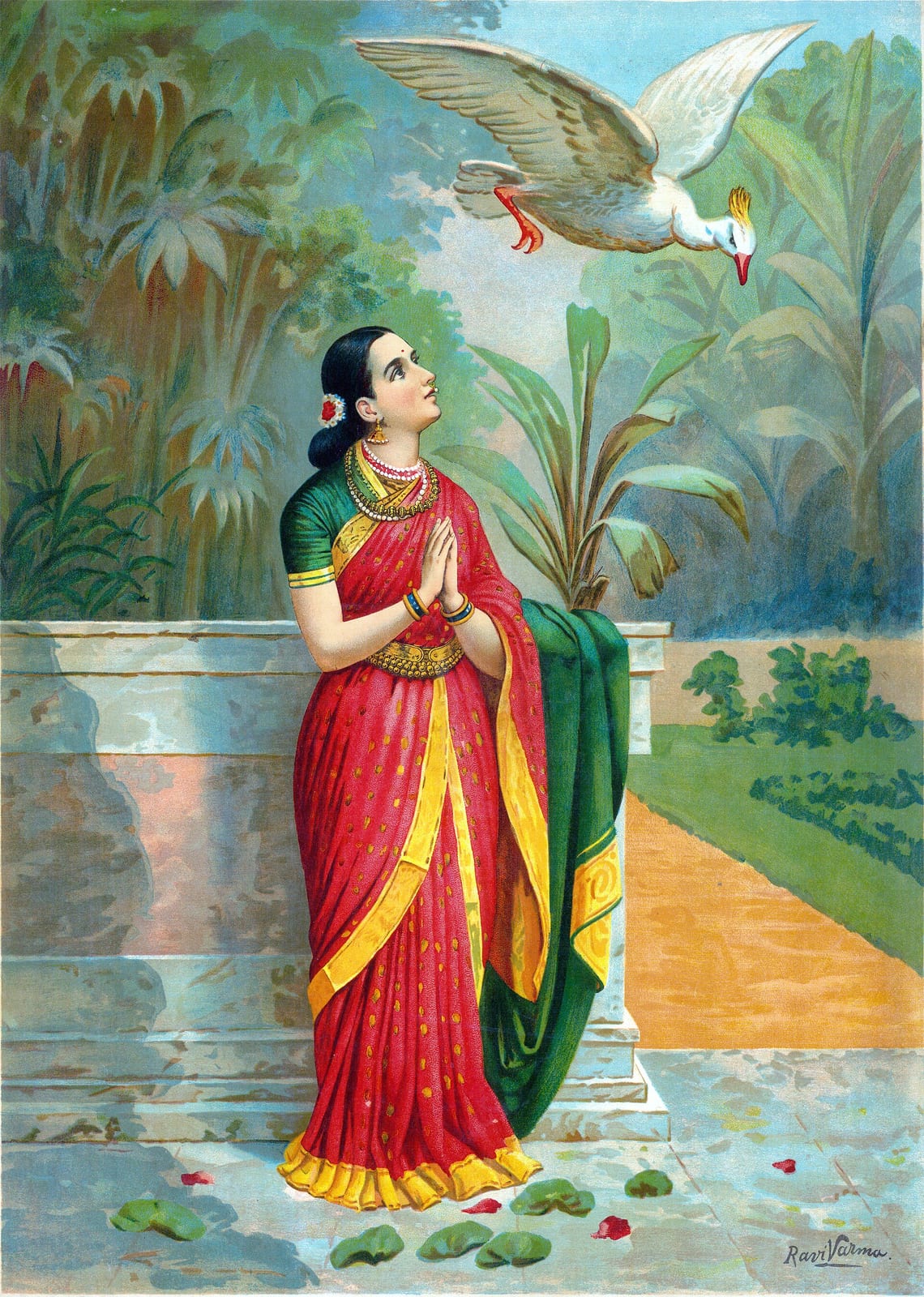 A woman in a red and gold sari with a green blouse stands at a stone balustrade in a garden, palms pressed together, looking up at a large white swan flying overhead with its beak open. Lotus pads and fallen petals lie on the flagstones; the print is signed Ravi Varma at lower right.